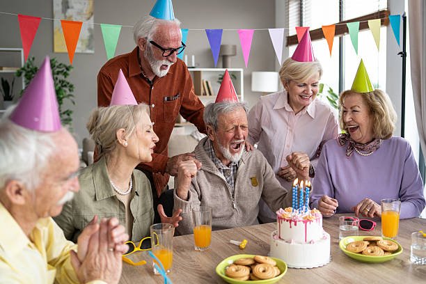 A joyful group of elderly friends cheer and celebrate at a vibrant birthday party, creating cherished memories on this special day together.